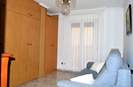 Bedroom 3 with wall wardrobe, sofa and door to the large patio